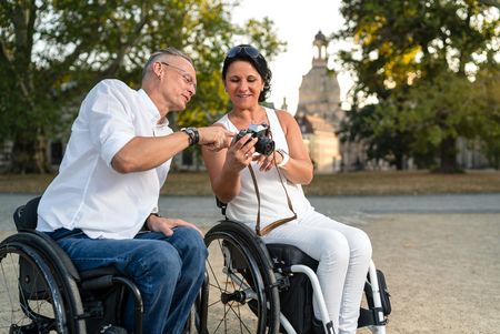 Zwei Rollstuhlfahrer mit Dresdner Frauenkirche im Hintergrund